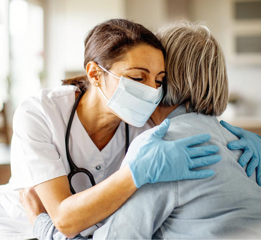 Profesional de la salud abrazando a una paciente